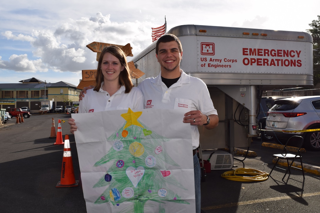 Leah and Evan Morgan, husband and wife team from Huntington District, U. S. Army Corps of Engineers, share the hand-drawn Christmas tree, sent to them by their Sunday school, age group 7 to 11, of First Missionary Baptist Church, Culloden, West Virginia. Leah, an administrative support assistant, deployed Nov. 14, and Evan, a civil engineer technician, joined her Dec. 22 to support the Corps Task Force Power Restoration mission.