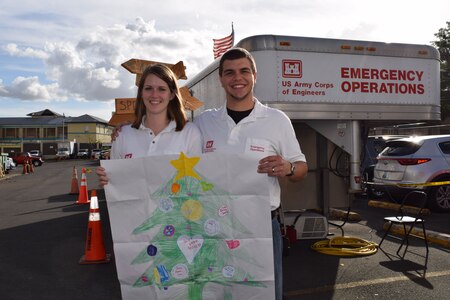 Leah and Evan Morgan, husband and wife team from Huntington District, U. S. Army Corps of Engineers, share the hand-drawn Christmas tree, sent to them by their Sunday school, age group 7 to 11, of First Missionary Baptist Church, Culloden, West Virginia. Leah, an administrative support assistant, deployed Nov. 14, and Evan, a civil engineer technician, joined her Dec. 22 to support the Corps Task Force Power Restoration mission.
