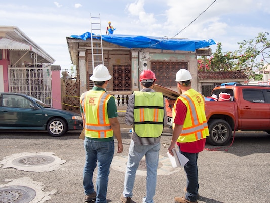 men evaluate blue roof installation