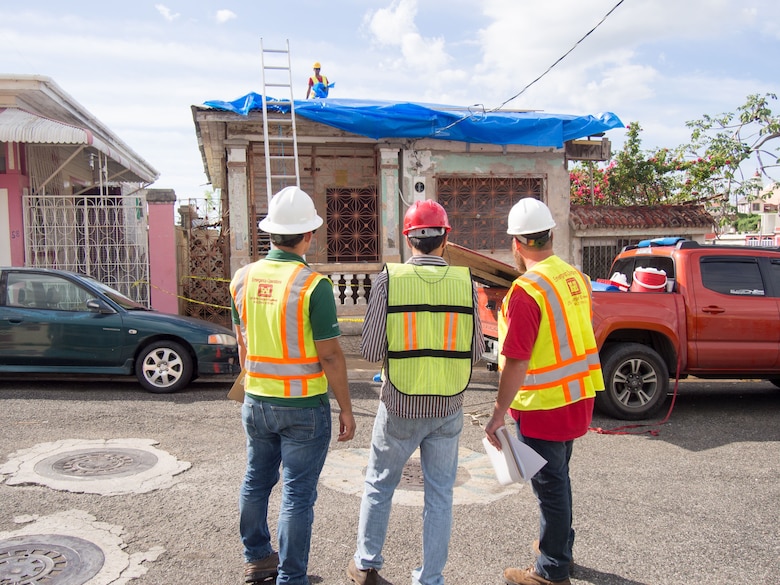 men evaluate blue roof installation