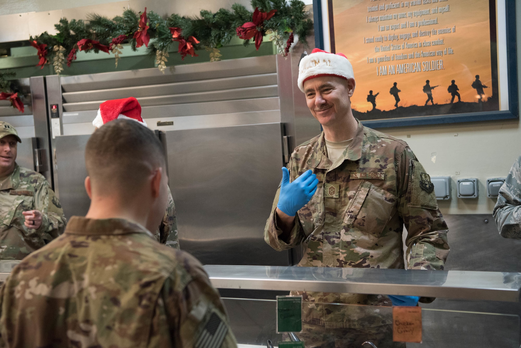 Chief Master Sgt. Ronald Anderson, Command Chief Master Sgt. of the Air National Guard, serves lunch to deployed military members at Al Udeid Air Base, Qatar, Dec. 24, 2017. Lt. Gen. L. Scott Rice, director of the Air National Guard, and Anderson visited deployed Air National Guardsmen at AUAB on Christmas Eve during a trip to the U.S. Central Command area of responsibility. (U.S. Air National Guard photo by Master Sgt. Phil Speck)