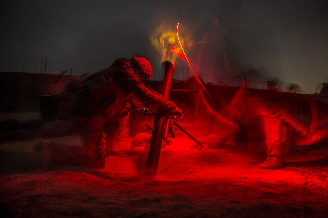 Soldiers fire a mortar at night to support Afghan soldiers.