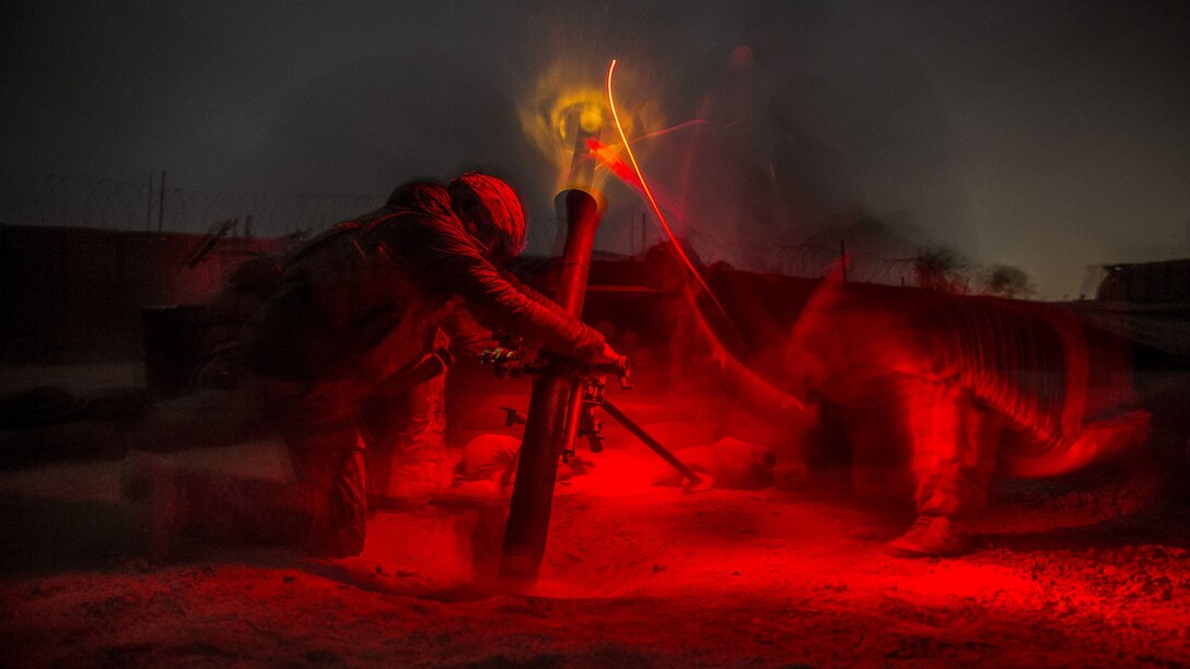 Soldiers fire a mortar at night to support Afghan soldiers.