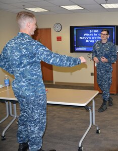 Petty Officer 2nd Class Samuel Donovan, left, a hospital corpsman serving at Naval Health Clinic Charleston, answers a $100 question about the Navy’s policy on drug use during NHCC’s “Impaired Driving Month Jeoparody Challenge” Dec. 20, 2017 at NHCC.