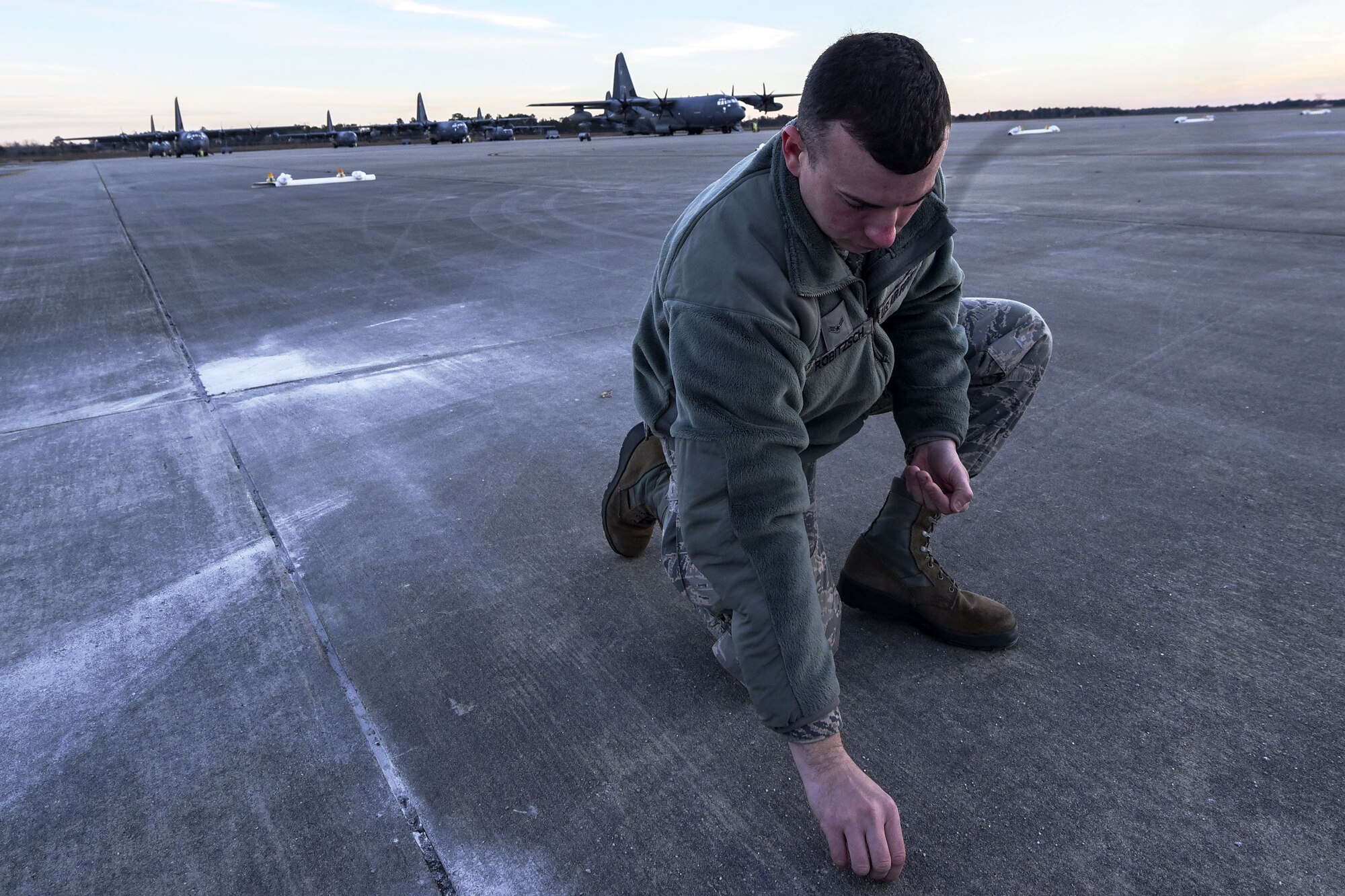 Senior Airman Reed Robitzsch, 23d Maintenance Squadron aircraft structural maintenance journeyman, picks up debris off the flight line during a foreign object debris (FOD) walk, Jan. 2, 2018, at Moody Air Force Base, Ga. The FOD walk was performed following the winter holidays to remove any debris that could potentially cause damage to aircraft or vehicles. (U.S. Air Force photo by Airman Eugene Oliver)