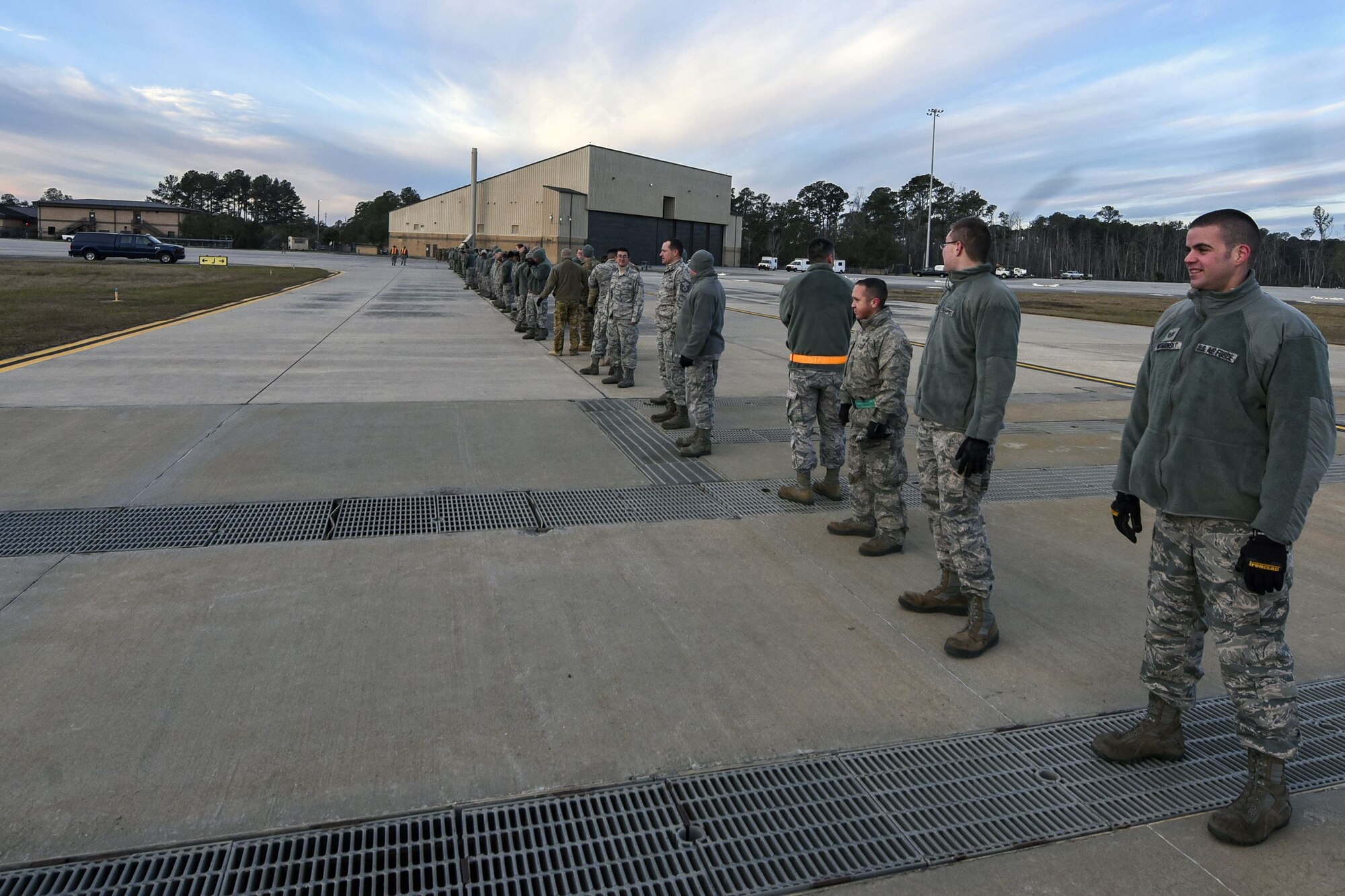 Team Moody Airmen stand in a line on the flight line during a foreign object debris (FOD) walk, Jan. 2, 2018, at Moody Air Force Base, Ga. The FOD walk was performed following the winter holidays to remove any debris that could potentially cause damage to aircraft or vehicles. (U.S. Air Force photo by Airman Eugene Oliver)