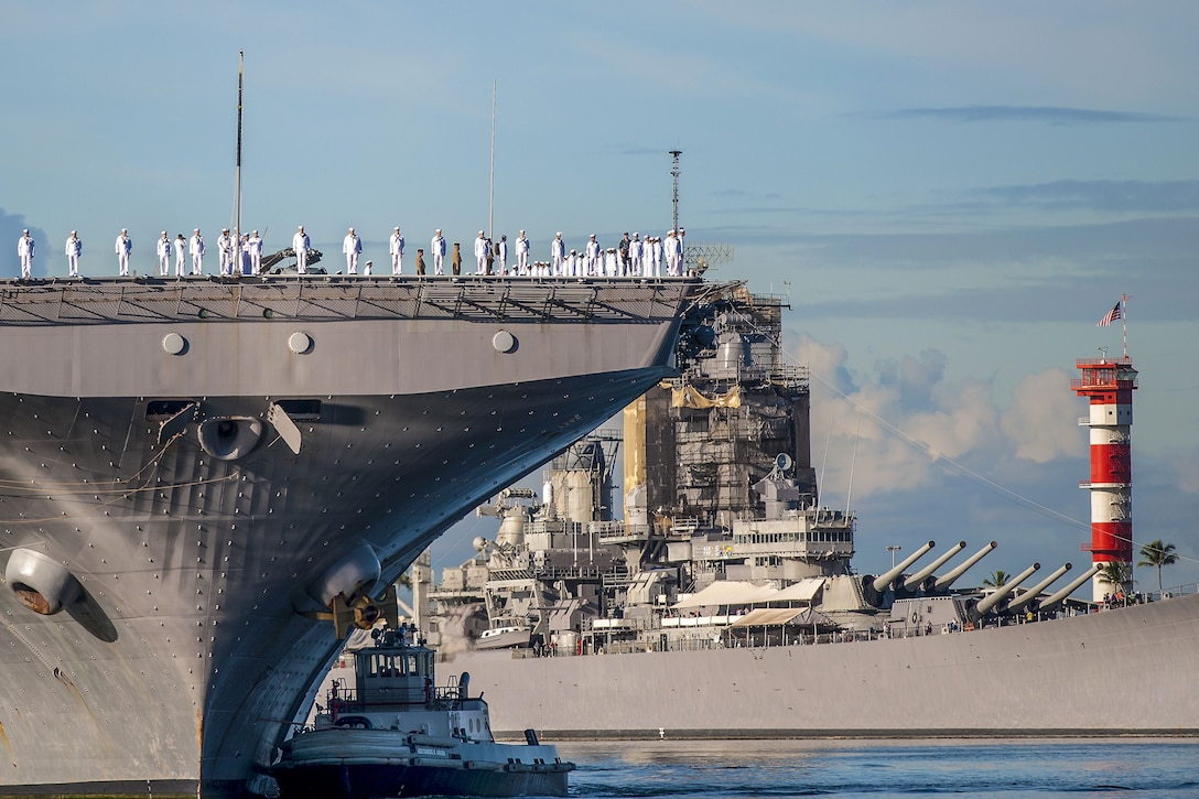 Sailors stand on a ship as it arrives in Pearl Harbor, Hawaii.