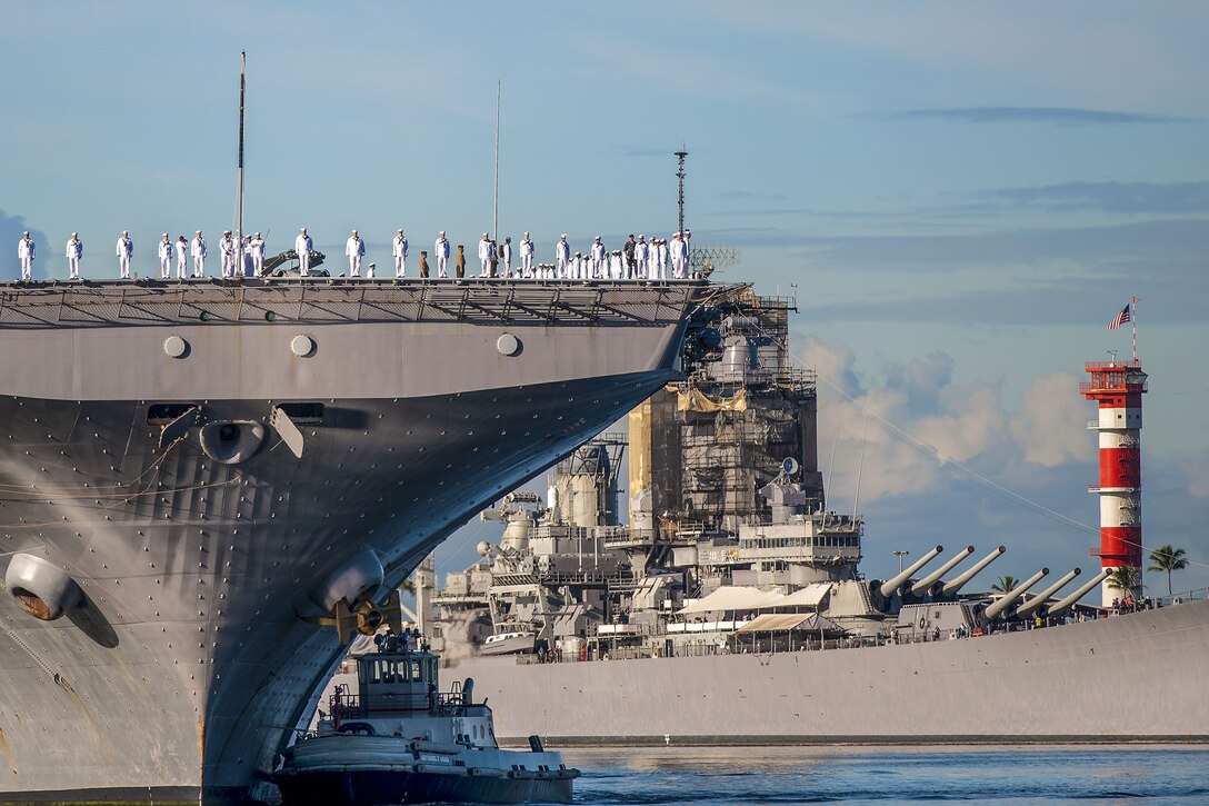 Sailors stand on a ship as it arrives in Pearl Harbor, Hawaii.