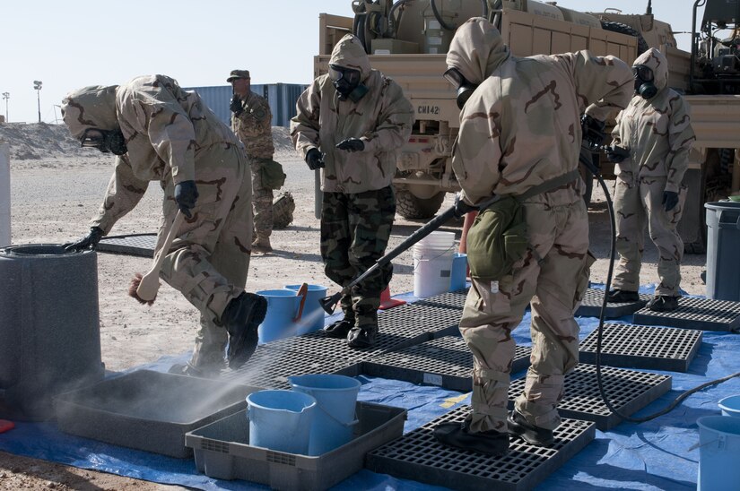 Soldiers work to decontaminate equipment.