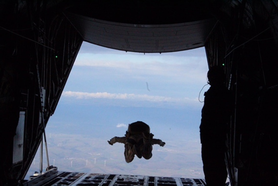 A paratrooper free-falls from a C-130 aircraft