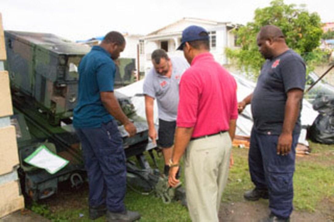 Technicians of the Dominica Fire Service inspect one of the generators sent in from DLA Disposition Services at Crane, Indiana, in preparation for transporting it to the fire station at Dominica’s lone international airport.