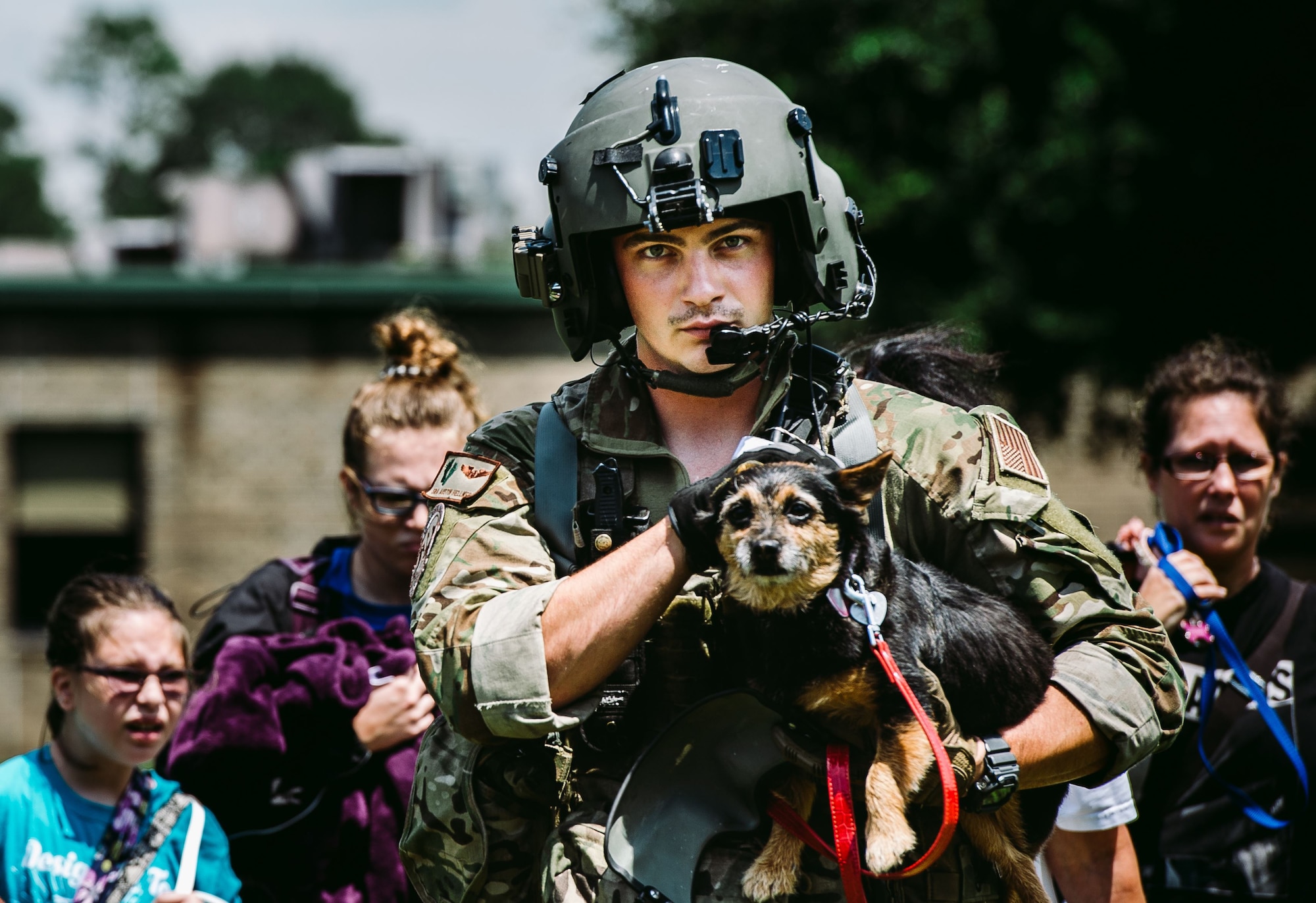 Senior Airman Austin Hellweg, 129th Rescue Squadron special missions aviator, carries a dog and leads a family into an HH-60 Pavehawk for extraction to a safer location during the relief effort for Hurricane Harvey, Aug. 31st, 2017, Beaumont, Texas. The relief efforts have a conglomerate of active, guard and reserve units from all branches aiding the federal government to help Texas recover from Hurricane Harvey. (U.S. Air Force photo by Staff Sgt. Jordan Castelan)