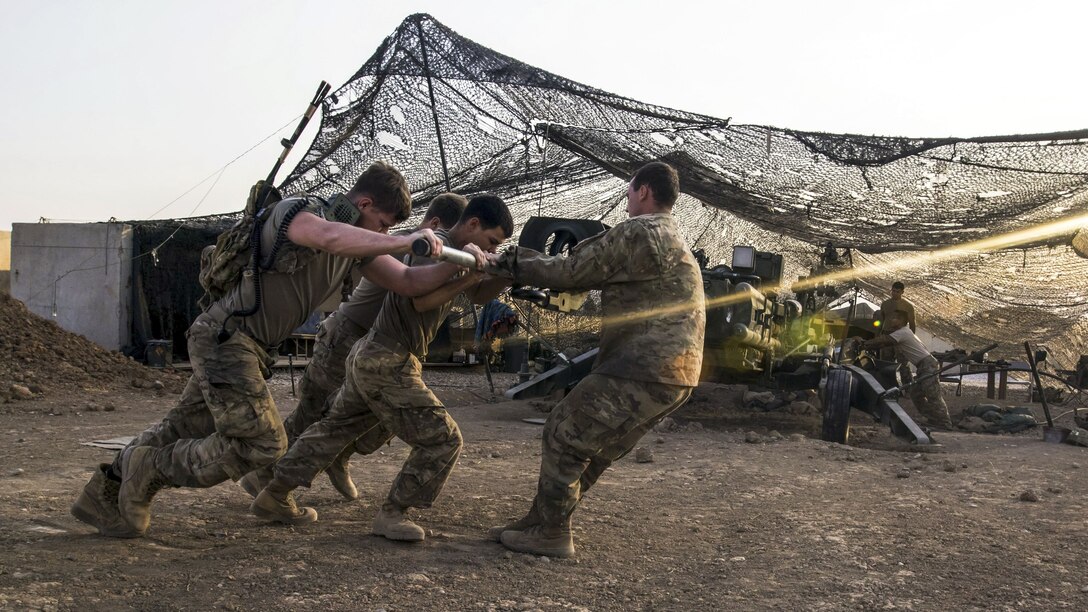 Soldiers rotate a howitzer to prepare to engage militants.