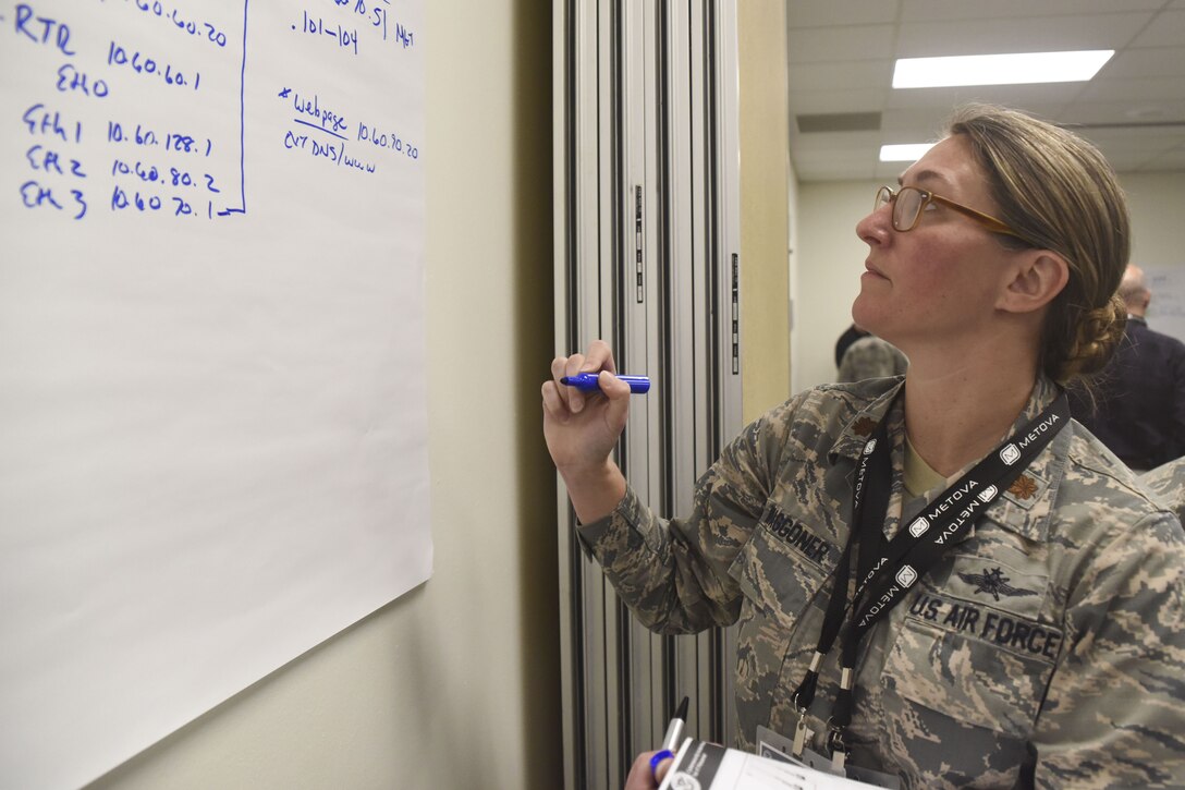 An airman writes on a drawing board.