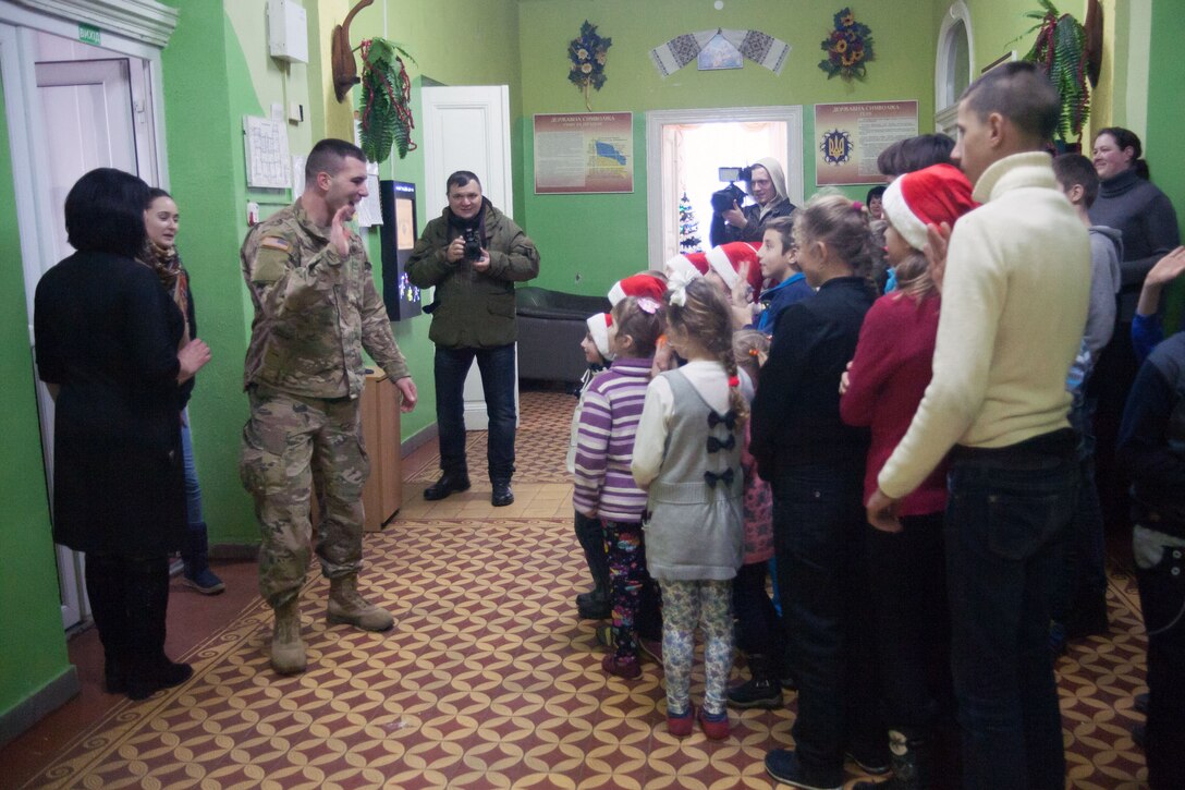 Soldiers interact with a group of children.
