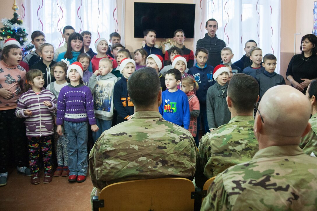 Children sing for soldiers.