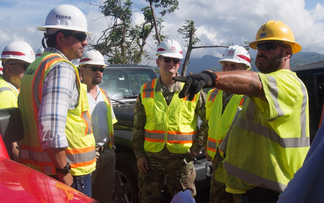 Maj. Gen. Donald E. "Ed" Jackson, the deputy commanding general for civil and emergency operations, U.S. Army Corps of Engineers, and Task Force Power Restoration Commander Col. John Lloyd are briefed by a worker from Corps contractor Fluor about work to restore power on a hill top in Canovanas, Puerto Rico, Jan. 4. USACE is partnering with the Puerto Rico Electric Power Authority, the Department of Energy, FEMA and contracted partners, to restore safe and reliable power to the people of Puerto Rico. As assigned by FEMA, USACE leads the federal effort to repair the hurricane-damaged electrical power grid in support of the Government of Puerto Rico. Puerto Rico Electric Power Authority reports 55 percent or 808,500 of the 1.47M customers who are able to receive electric power have their service restored.