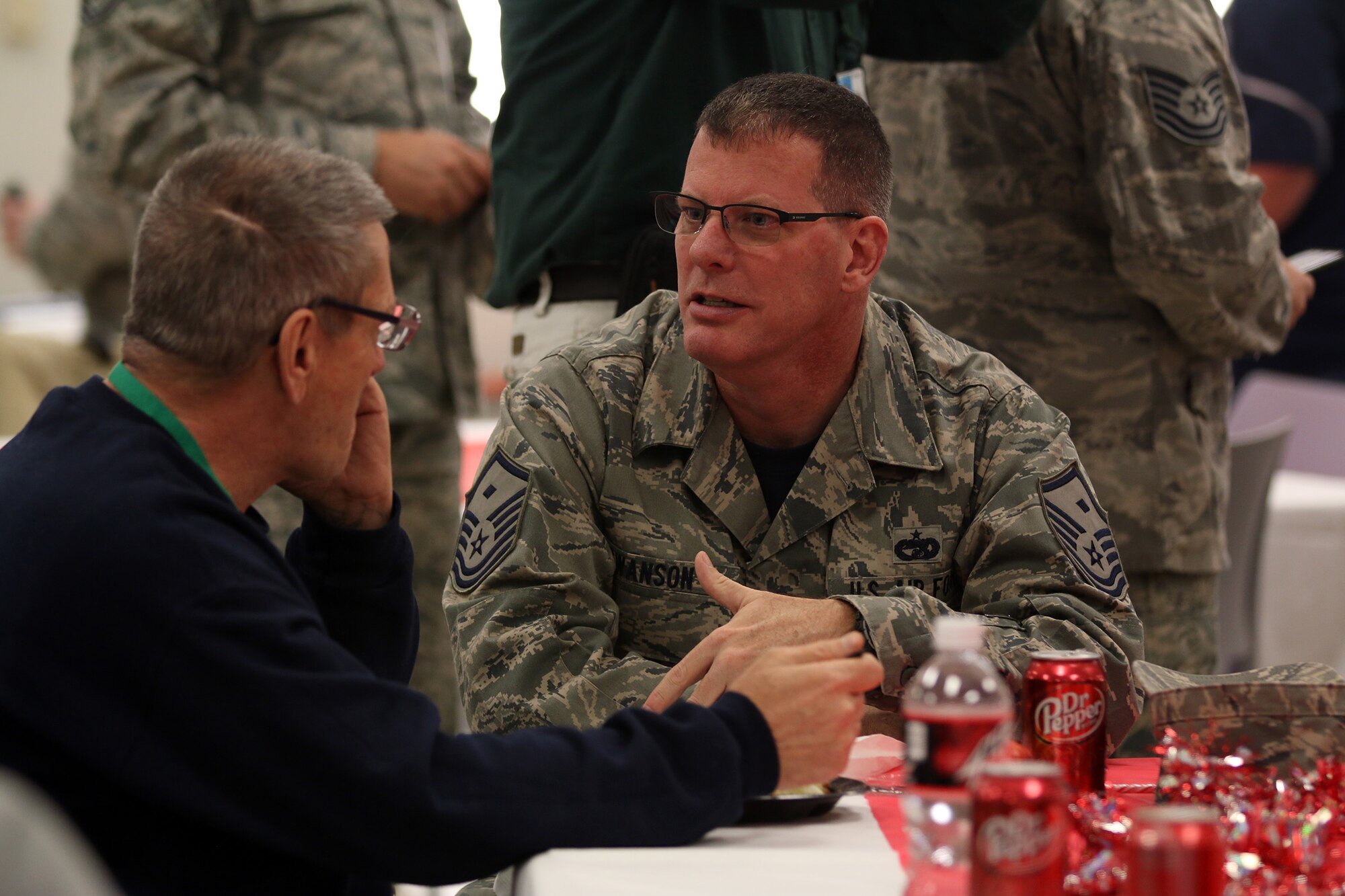 Master Sergeant Jay L. Swanson, 445th Force Support Squadron first sergeant, talks to a veteran during the Dayton Veterans Affairs Medical Center complex Christmas party luncheon December 2, 2017