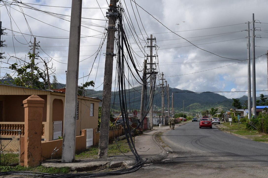 USACE Task Force Power Restoration Commander Col. John P. Lloyd (foreground) and TF Power Operations Officer Capt. Aaron Anderson survey the damage wrought by Hurricane Maria as they walk through a neighborhood in Maunabo, Puerto Rico, on Jan. 3. To date, Anderson’s team has set-up microgrids in five locations, starting with Culebra Island. The next four were placed in the Southeast, which was ground zero, sustaining tremendous damage when Hurricane Maria made landfall. These microgrids are operating in Patillas, Maunabo, Naguabo and Yabucoa, Puerto Rico.