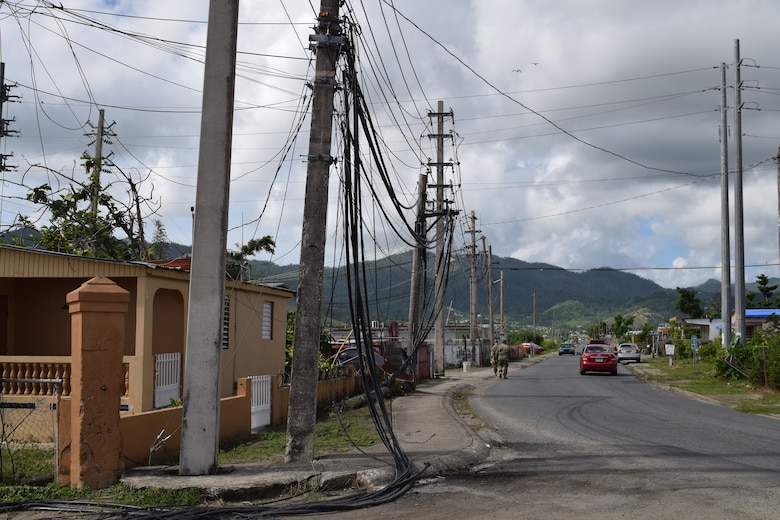 USACE Task Force Power Restoration Commander Col. John P. Lloyd (foreground) and TF Power Operations Officer Capt. Aaron Anderson survey the damage wrought by Hurricane Maria as they walk through a neighborhood in Maunabo, Puerto Rico, on Jan. 3. To date, Anderson’s team has set-up microgrids in five locations, starting with Culebra Island. The next four were placed in the Southeast, which was ground zero, sustaining tremendous damage when Hurricane Maria made landfall. These microgrids are operating in Patillas, Maunabo, Naguabo and Yabucoa, Puerto Rico.