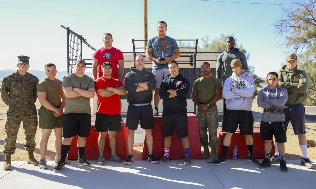 Marines with Marine Wing Support Squadron 374 stand with the winners of the Iron Rhino weightlifting competition at Del Valle High Intensity Tactical Training field aboard the Marine Corps Air Ground Combat Center, Twentynine Palms, Calif., Dec. 13, 2017. The Iron Rhino event was the first weightlifting competition hosted by MWSS-374 where competitors had three attempts to reach their maximum deadlift, bench, and squat, to claim the title of Iron Rhino. (U.S. Marine Corps photo by Cpl. Christian Lopez)