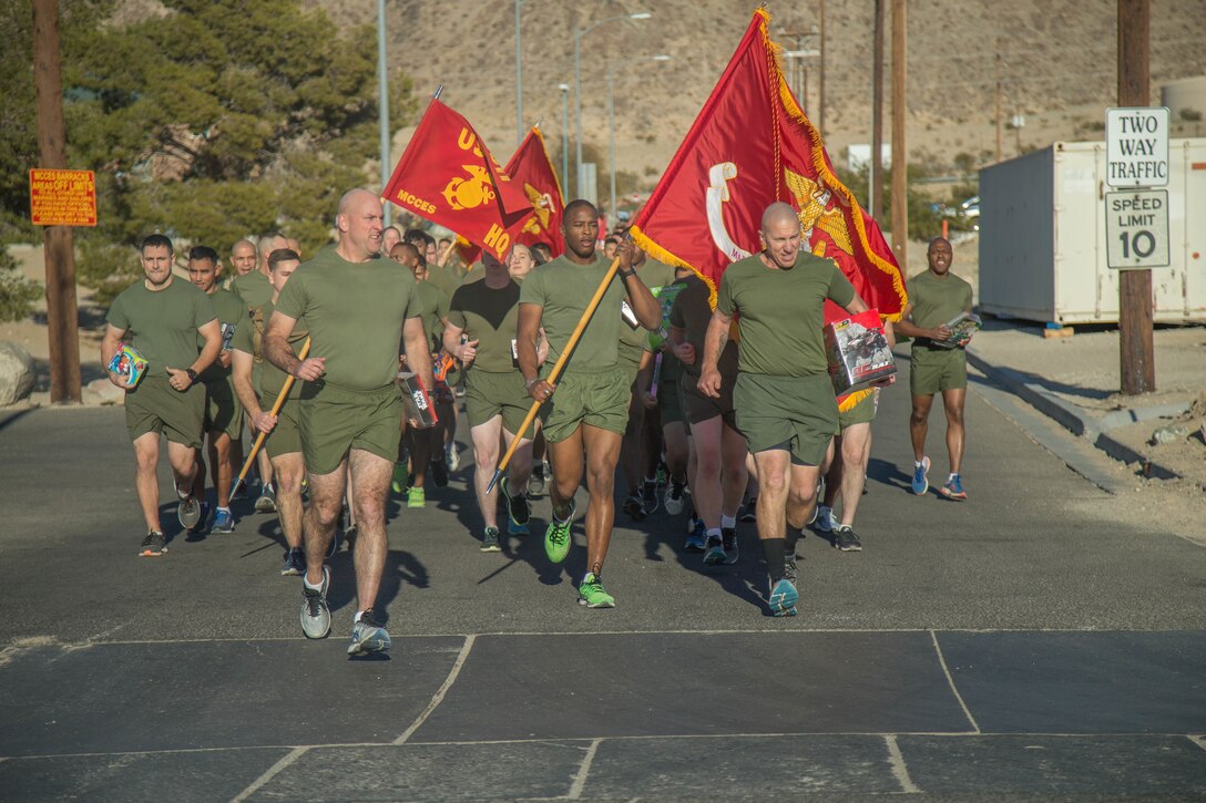 Marines with the Marine Corps Communication-Electronics School run during the annual Toys-for-Tots Run aboard the Marine Corps Air Ground Combat Center, Twentynine Palms, Calif., Dec. 18, 2017. Marines ran with toys and dropped them off in front of the Commanding General’s building. (U.S. Marine Corps photo by Lance Cpl. Preston L. Morris)