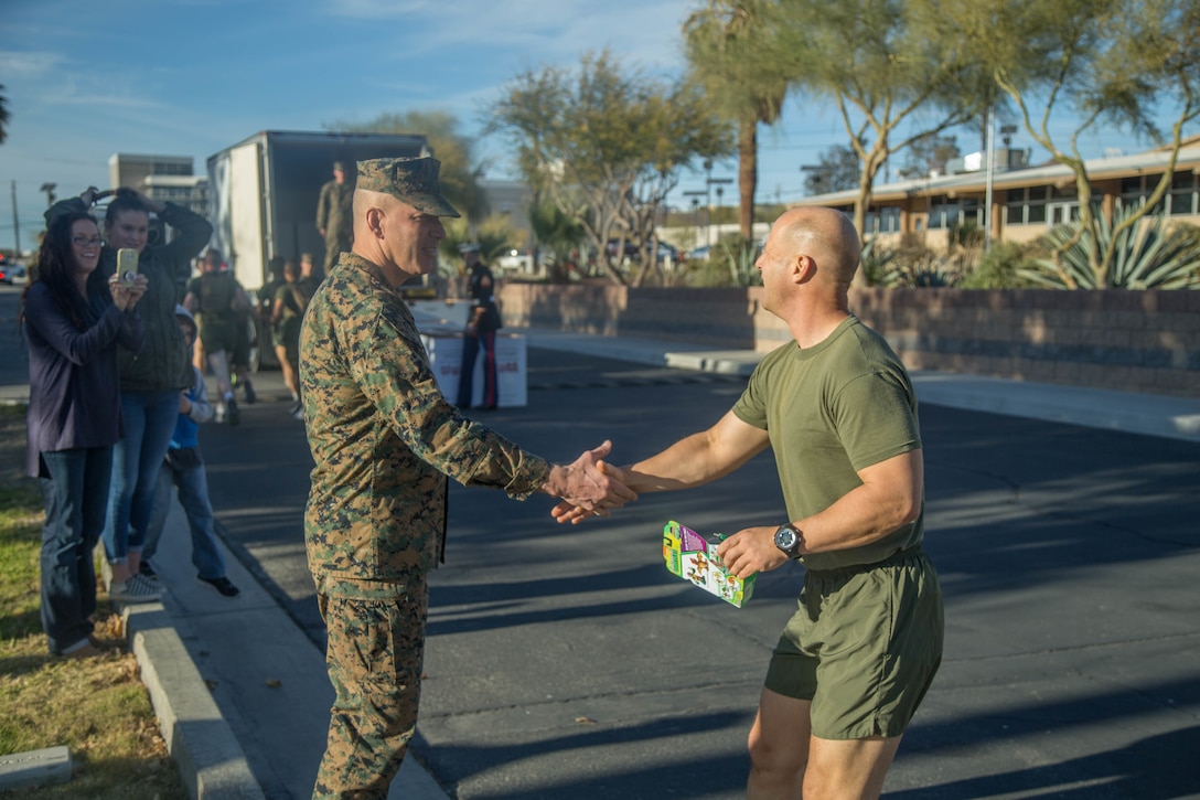 Maj. Gen. William F. Mullen III, Commanding General, Marine Corps Air Ground Combat Center, Twentynine Palms, Calif., receives the first toy during the annual Toys-for-Tots Run aboard the base, Dec. 18, 2017. Marines ran with toys and dropped them off in front of the Commanding General’s building. (U.S. Marine Corps photo by Lance Cpl. Preston L. Morris)