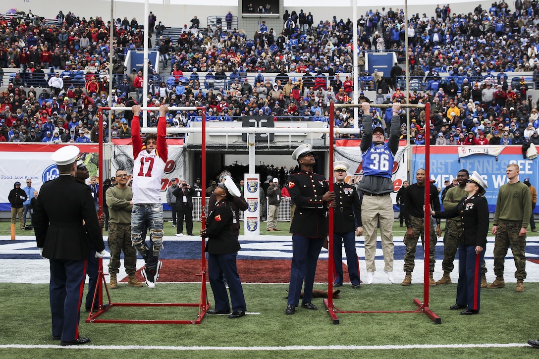Two high school students compete in the AutoZone Liberty Bowl/Marines Chin-Up Challenge at the Liberty Bowl Memorial Stadium in Memphis, Tennessee, Dec. 30, 2017. The two finalists, Lance West, from Brighton High School, and Jarret Fowlkes, from Christian Brothers High School, were the top performing students from local schools. They had 30 seconds to complete as many Marine Corps chin-ups as they could. West was the overall Chin-Up Challenge champion. (U.S. Marine Corps photo by Sgt. Mandaline Hatch)