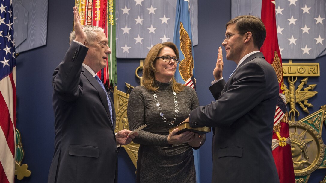 Defense Secretary James N. Mattis stands across from a man being sworn into office.