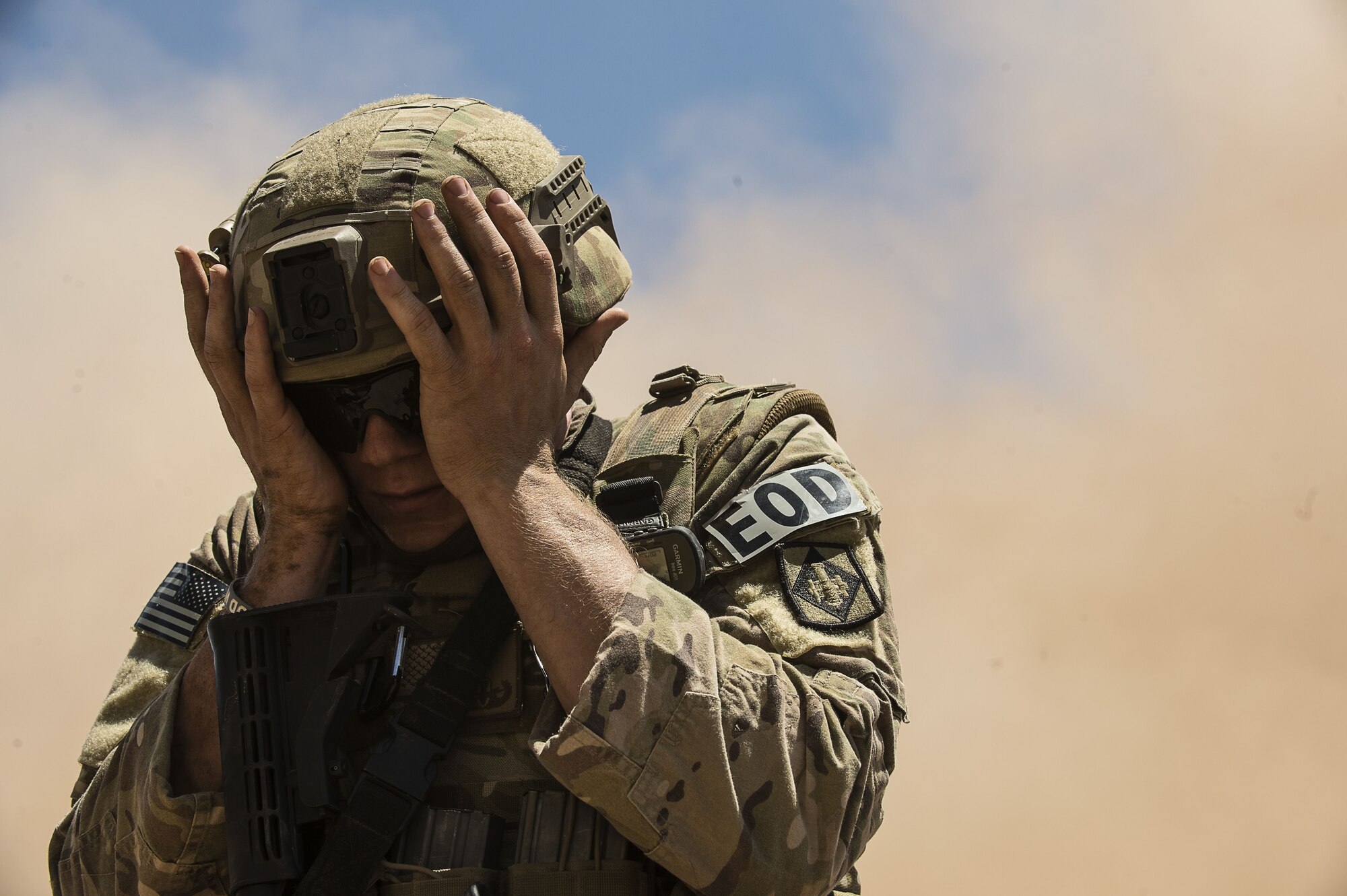 Airman 1st Class Jared Ball, EOD team member, shields his face from oncoming sand during fly-away training at the Florence Military Reservation in Florence, Ariz., July 21, 2017. The wind gusts caused from the Black Hawks take-off and landing kick up sand from the desert floor causing low visibility. To reduce the uncertainty in different scenarios, the 56th Civil Engineer Squadron EOD team conducts fly-away training in an ongoing attempt to enhance skills needed in a deployed environment. (U.S. Air Force photo/Airman 1st Class Alexander Cook)