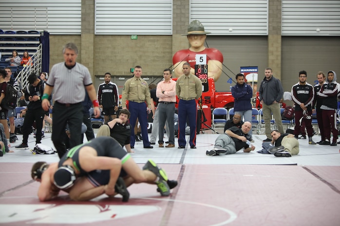 Gunnery Sgt. Gene Bradley and 1st Lt. Terrence Stephens watch wrestlers compete during the 2018 National Wrestling Coaches Association National Duals at the Allen County War Memorial Coliseum at Fort Wayne, Indiana, Jan. 4. Marines and wrestlers share similarities. The Marine Corps believes wrestlers possess certain characteristics and qualities that make them better suited for life as a Marine. (U.S. Marine Corps photo by Cpl. Quavaungh Pointer)