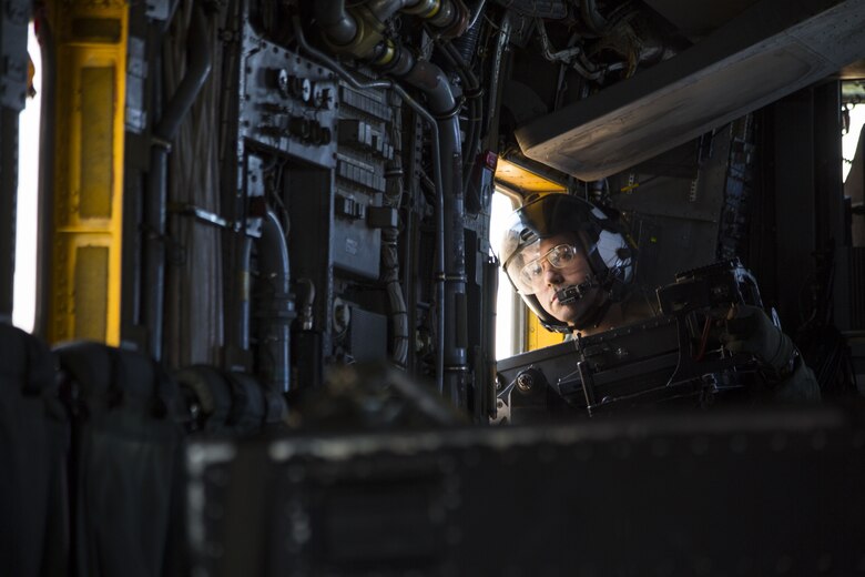U.S. Marine Corps Lance Cpl. Kyle Missel, a crew chief assigned to Marine Heavy Helicopter Squadron (HMH) 465, looks inside the CH-53E Super Stallion as it flies above the Chocolate Mountain Aerial Gunnery Range, Dec. 9, 2017. HMH-465 arrived to MCAS Yuma, Nov. 29, 2017 to conduct training in support of Exercise Winter Fury. Exercise Winter Fury allows Marines to exercise the skills needed as the combat element of the Marine Air Ground Task Force during a combat deployment. (U.S. Marine Corps photo by Cpl. Isaac D. Martinez)