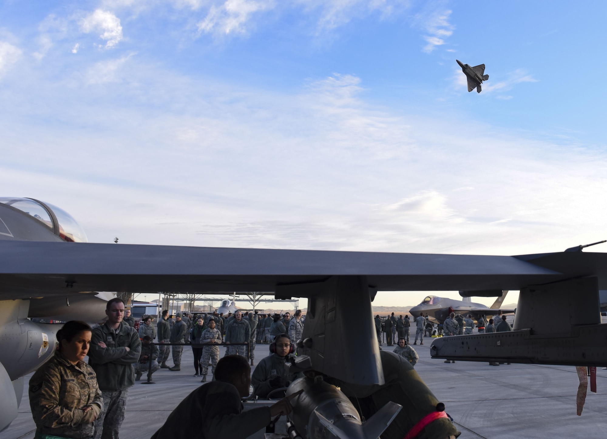 An F-22 Raptor fighter jet passes over the quarterly load crew competition at Nellis Air Force Base, Nev., Jan. 5, 2018. Load crew competitions challenge the teams’ capabilities to load munitions on aircraft in an accurate, safe and timely manner. (U.S. Air Force photo by Airman 1st Class Andrew D. Sarver/Released)