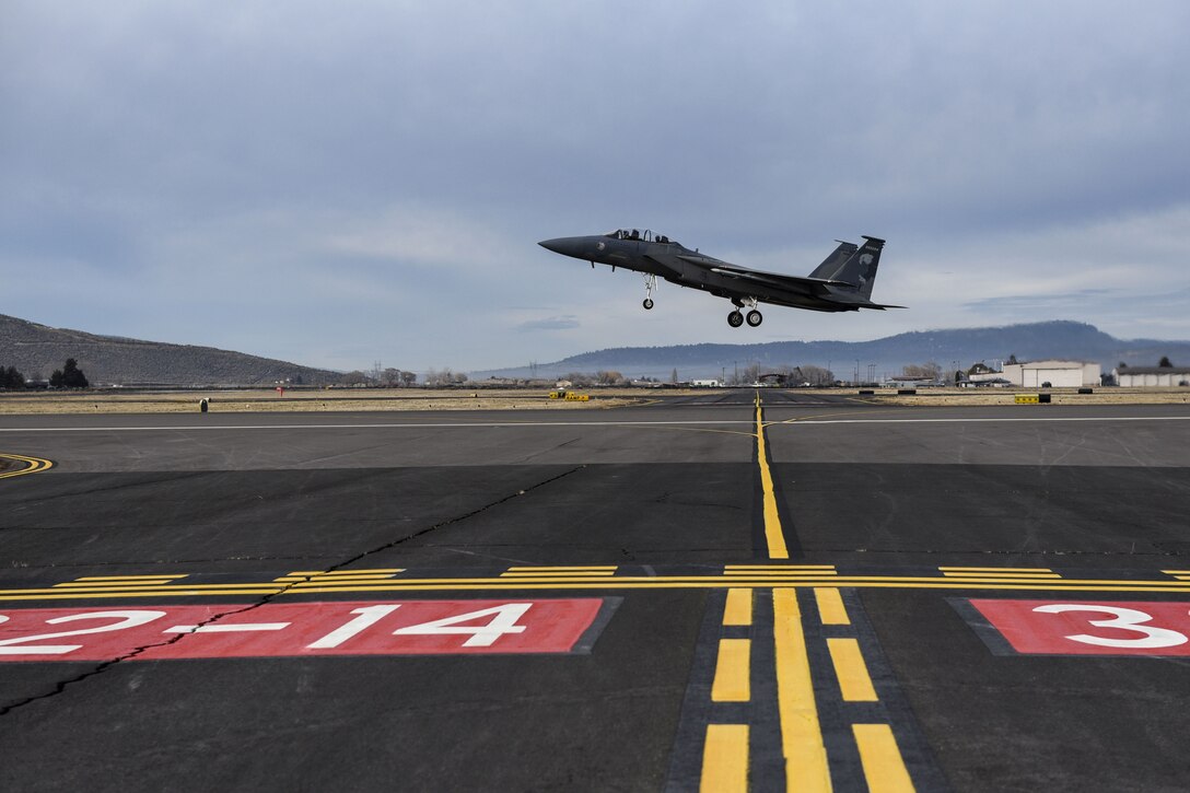 An aircraft takes off from a flight line.