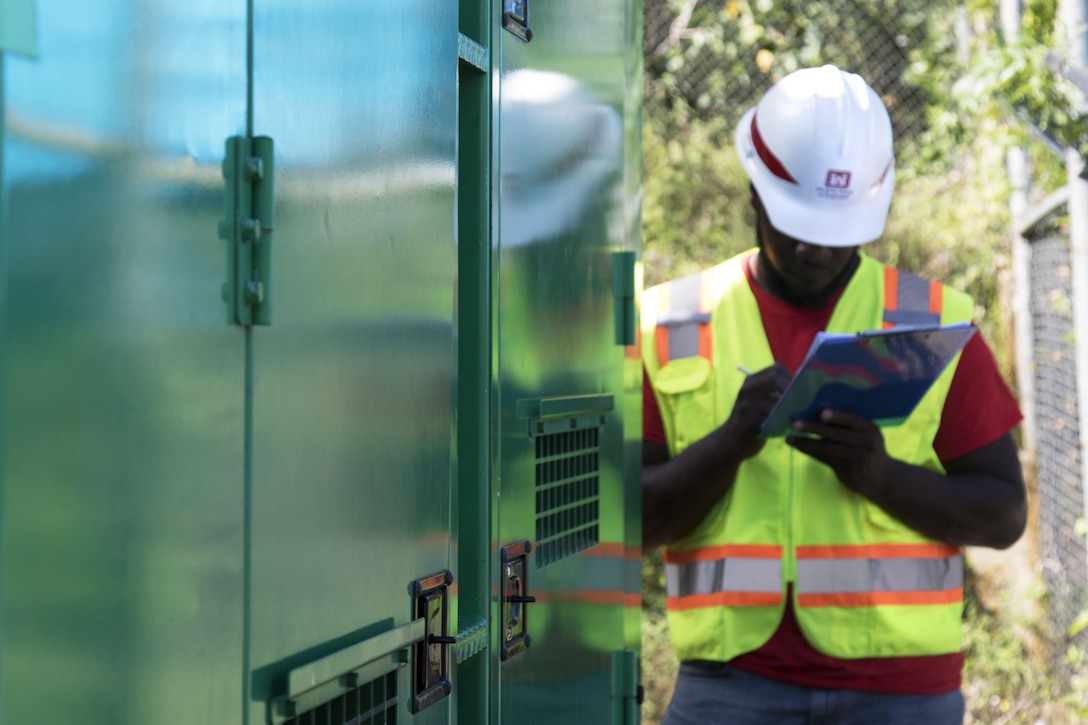 man inspects generator