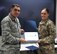 The commander of the 932nd Airlift Wing, Col. Raymond Smith, presents a certificate for the outstanding military bearing award to Staff Sergeant Nicole Frost Jan. 5, 2018, at Scott Air Force Base, Ill..  She also received a coin and another award for being an overall superior performer during the UEI capstone week, as chosen by the inspectors.  (U.S. Air Force photo by Lt. Col. Stan Paregien)