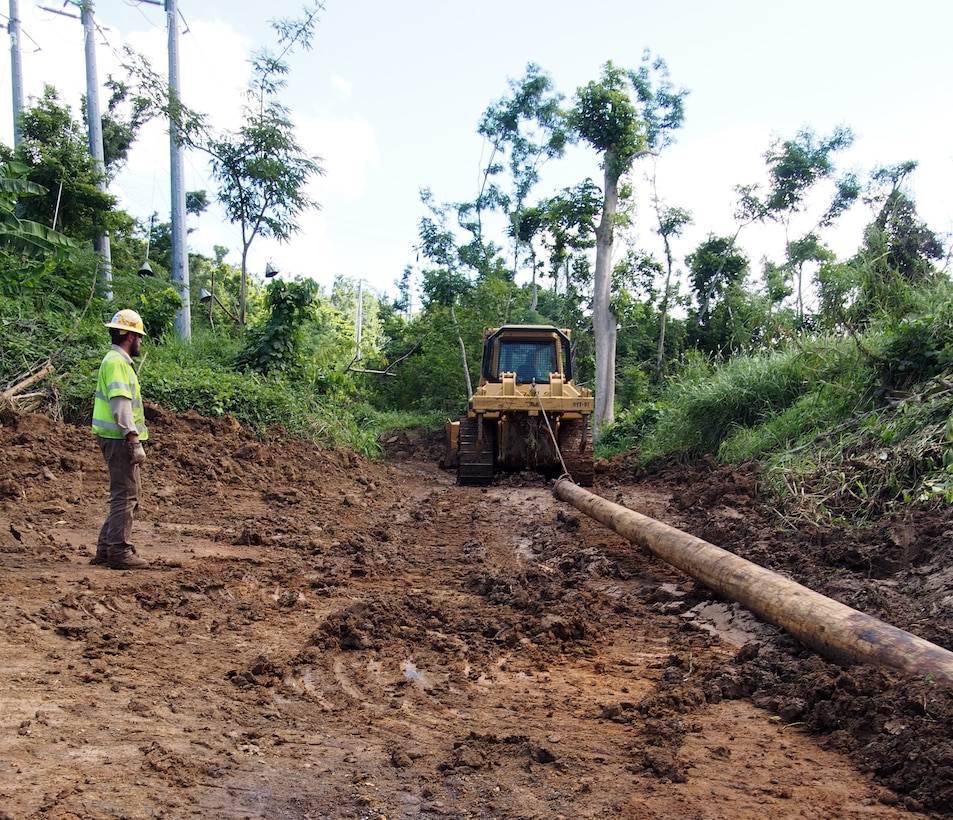 Emergency relief crews working with Army Corps of Engineers, Task Force Power Restoration, pull a wooden power pole up a newly created road to as part of the ongoing effort to restore power to the Trujillo Alto, Puerto Rico, Christmas Eve, 2017.  USACE is partnering with the Puerto Rico Electric Power Authority, the Department of Energy and FEMA and contracted partners, to restore safe and reliable power to the people of Puerto Rico. As assigned by FEMA, USACE leads the federal effort to repair the hurricane-damaged electrical power grid in support of the Government of Puerto Rico. Puerto Rico Electric Power Authority reports 59.4 percent or 875,500 of the 1.47M customers who are able to receive electric power have their service restored.