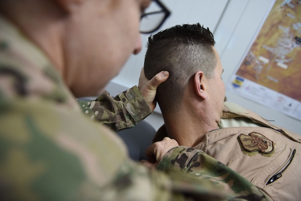 Lt. Col. Tisha Sutton, 332d Expeditionary Medical Group physical therapist, guides a pilot from the 332d Expeditionary Fighter Squadron through a set of flexibility exercises January 3, 2018 in Southwest Asia. Flying 6-8-hour combat sorties at night requires pilots to wear helmet-mounted night vision systems, which places increased strain on the neck. (U.S. Air Force photo by Staff Sgt. Joshua Kleinholz)