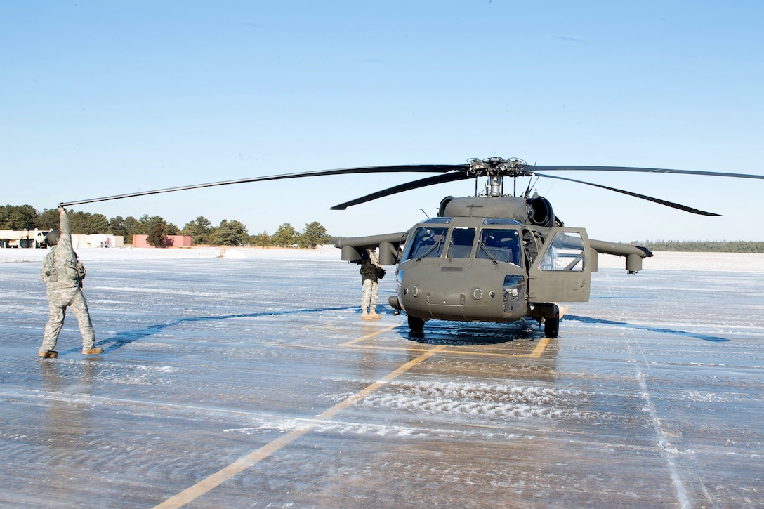 Guardsmen prepare their UH-60 Black Hawk helicopter for takeoff.