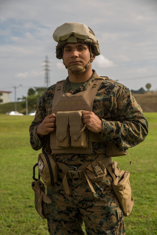 Marine in battle gear poses for a photo in Okinawa, Japan.