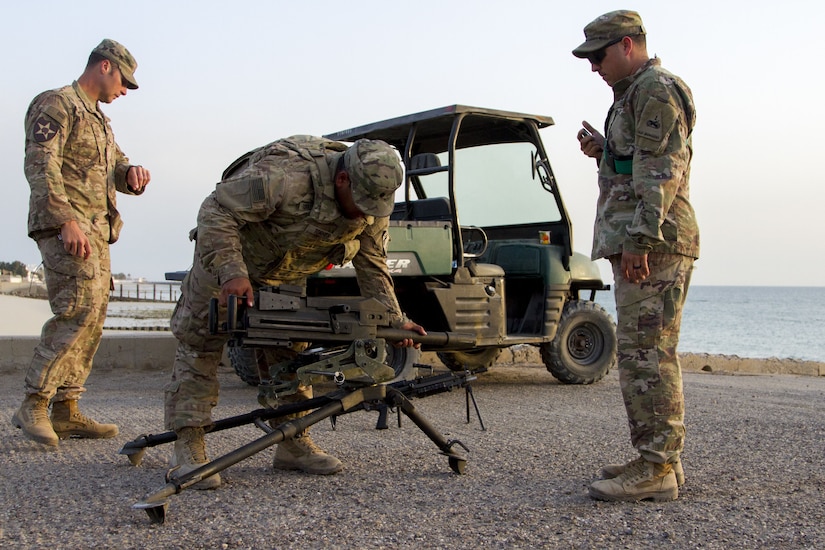 Three Soldiers assembling a grenade launcher.