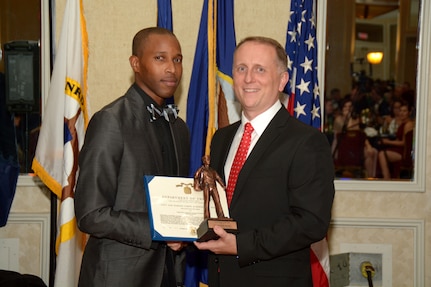 Petty Officer 2nd Class Dennis Mitchell (left), a Navy recruiter assigned to Navy Recruiting Station Round Rock, Navy Recruiting District San Antonio, stands with Commanding Officer Cmdr. Jeffrey Reynolds after being awarded NRD’s Junior Sailor of the Year for Fiscal Year 2017 during the NRD’s annual award banquet held at the Crowne Plaza Hotel in Austin Dec. 19, 2017. Mitchell became a recruiter to build a better Navy and help young adults who don’t know what to do with their lives. “This award means that I have taken my job as a Sailor seriously and proudly,” Mitchell said. “It’s an honor to come home to my children and tell them that I am the Junior Sailor of the Year. It motivates them to do great in life.” Mitchell was also awarded the Navy and Marine Corps Achievement Medal for his superior performance of duty.