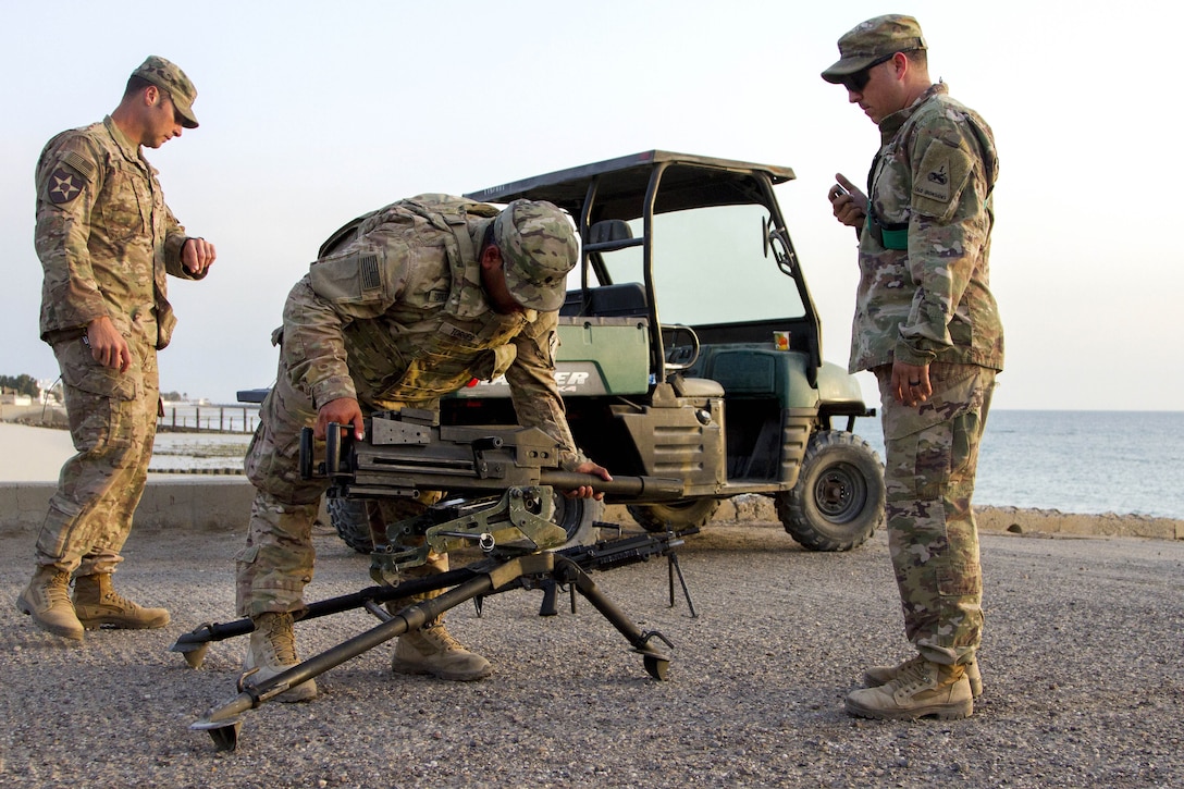 Army Spc. Bryan Torresfierro, center, assembles a Mark 19 grenade launcher.