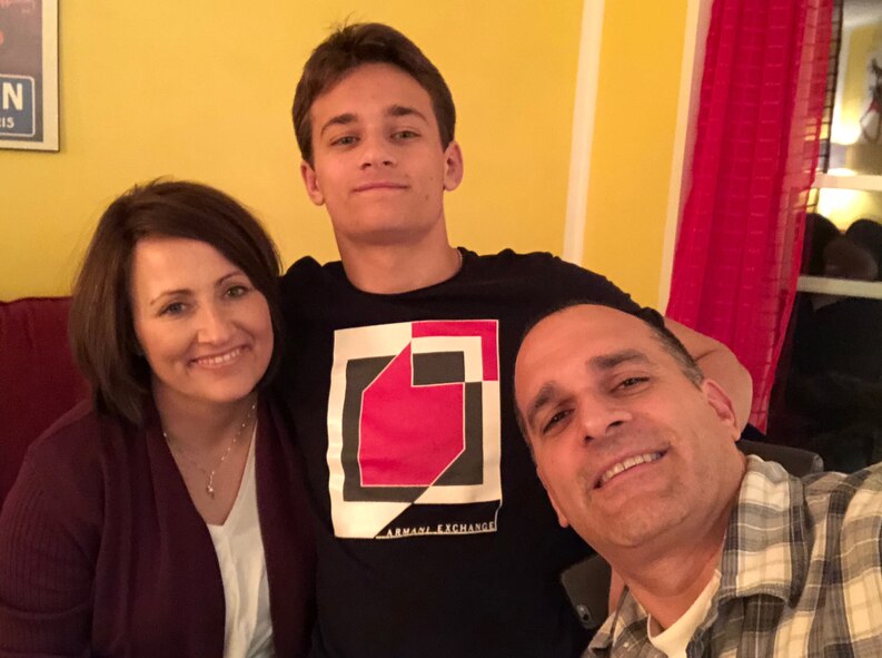 U.S. Air Force Medical Service Corps Officer, Maj. Stephanie Proellochs (left) poses for a photo with her son, JP (center), and husband, John (right) in their home. Both her son and her husband have been with Proellochs through every step of her cancer journey and accompany her to every appointment ever since her diagnosis in January 2017. (Courtesy Photo)