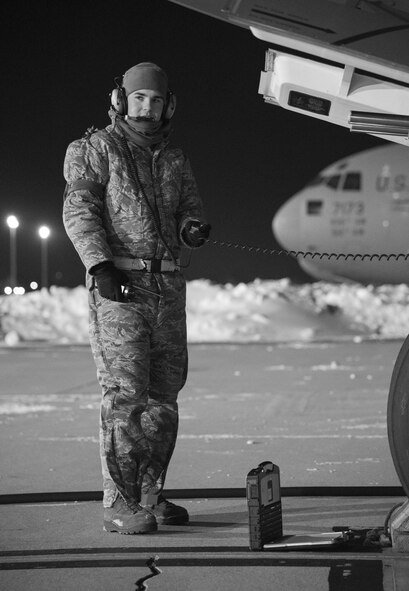 Senior Airman Garrett Battle, 736th Aircraft Maintenance Squadron communication and navigation journeyman, stands near the nose of a C-17A Globemaster III as the aircraft is being refueled, Jan. 5, 2018, at Dover Air Force Base, Del. Battle and other 736th AMXS maintainers prepared the aircraft for a mission in temperatures in the low teens with a wind chill hovering around minus three degrees. (U.S. Air Force photo by Roland Balik)