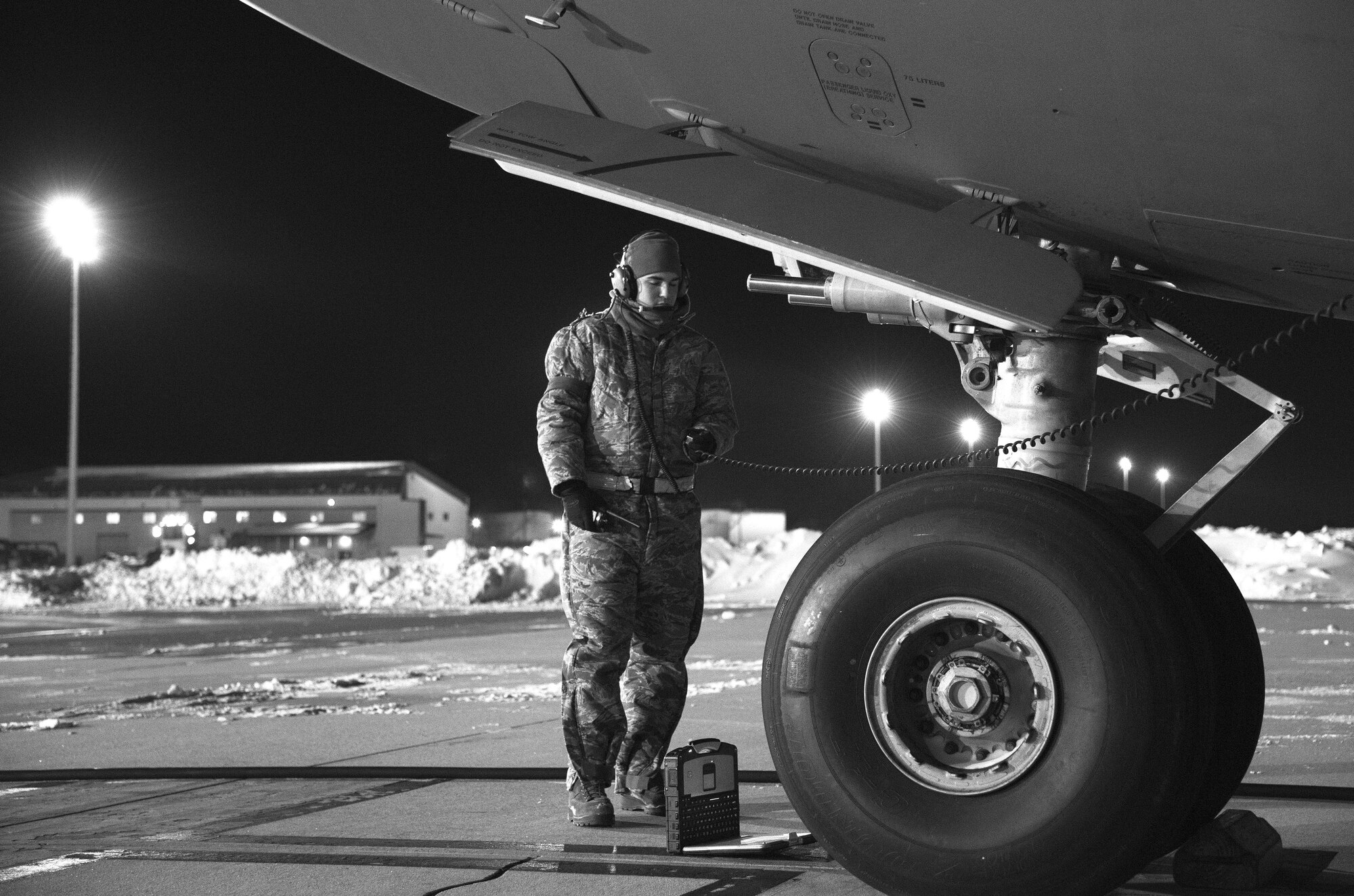 Senior Airman Garrett Battle, 736th Aircraft Maintenance Squadron communication and navigation journeyman, stands near the nose of a C-17A Globemaster III as the aircraft is being refueled, Jan. 5, 2018, at Dover Air Force Base, Del. Battle and other 736th AMXS maintainers prepared the aircraft for a mission in temperatures in the low teens with a wind chill hovering around minus three degrees. (U.S. Air Force photo by Roland Balik)