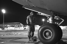 Senior Airman Garrett Battle, 736th Aircraft Maintenance Squadron communication and navigation journeyman, stands near the nose of a C-17A Globemaster III as the aircraft is being refueled, Jan. 5, 2018, at Dover Air Force Base, Del. Battle and other 736th AMXS maintainers prepared the aircraft for a mission in temperatures in the low teens with a wind chill hovering around minus three degrees. (U.S. Air Force photo by Roland Balik)