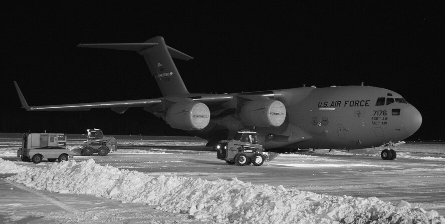Maintenance personnel from the 736th Aircraft Maintenance Squadron use Bobcats to clear snow around a C-17A Globemaster III, Jan. 5, 2018, at Dover Air Force Base, Del. The 436th Operations Support Squadron weather flight recorded eight inches of snow fell on the base from Winter Storm Grayson. (U.S. Air Force photo by Roland Balik)