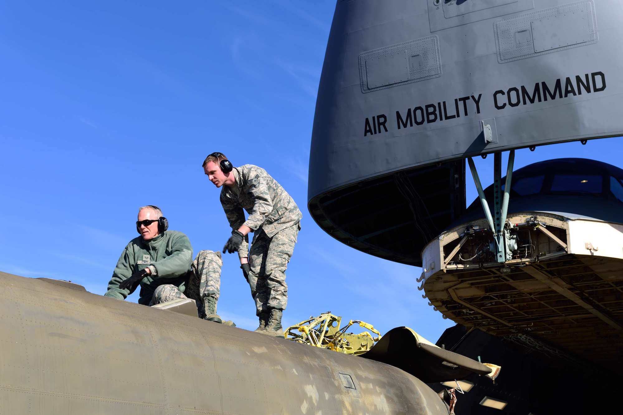 Staff Sgt. Jim Cagle and Senior Airman Preston Spear, 41st Aerial Port Squadron air transportation technicians out of Keesler Air Force Base, Miss., check the clearance of a CH-47 Chinook helicopter to make sure it will fit into cargo bay of the C-5M Super Galaxy aircraft at the Gulfport Combat Readiness Training Center – Battlefield Airman Center, Miss., Jan. 6, 2018.  Reservists, guardsmen, civilians and active-duty members from the Air Force, Army and Navy worked side by side during this training event called Breaking Barriers GRIP III Jan. 5-7, highlighting the joint effort of this training opportunity. (U.S. Air Force photo by Tech. Sgt. Ryan Labadens)