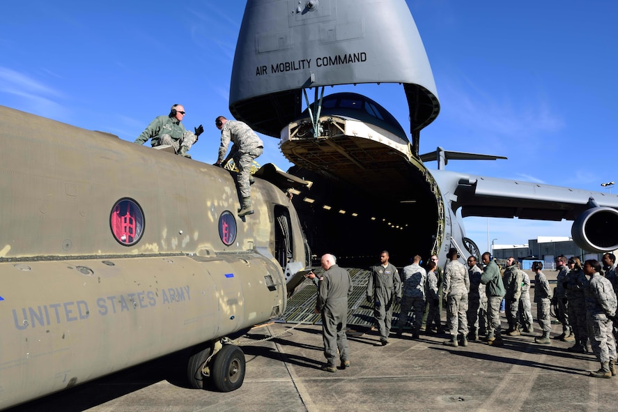 Reservists from the 41st Aerial Port Squadron and other service members from various units prepare to load a CH-47 Chinook helicopter onto a C-5M Super Galaxy from the 709th Airlift Squadron at the Gulfport Combat Readiness Training Center – Battlefield Airman Center, Miss., Jan. 6, 2018. Reservists, guardsmen, civilians and active-duty members from the Air Force, Army and Navy worked side by side during this training event called Breaking Barriers GRIP III Jan. 5-7, highlighting the joint effort of this training opportunity. (U.S. Air Force photo by Tech. Sgt. Ryan Labadens)